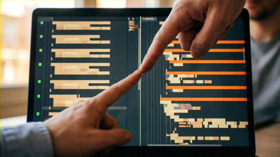 ['Two human collaborators', 'A software dashboard interface']. Interactive peer review or technical consultation. Software Engineering and Data Visualization.